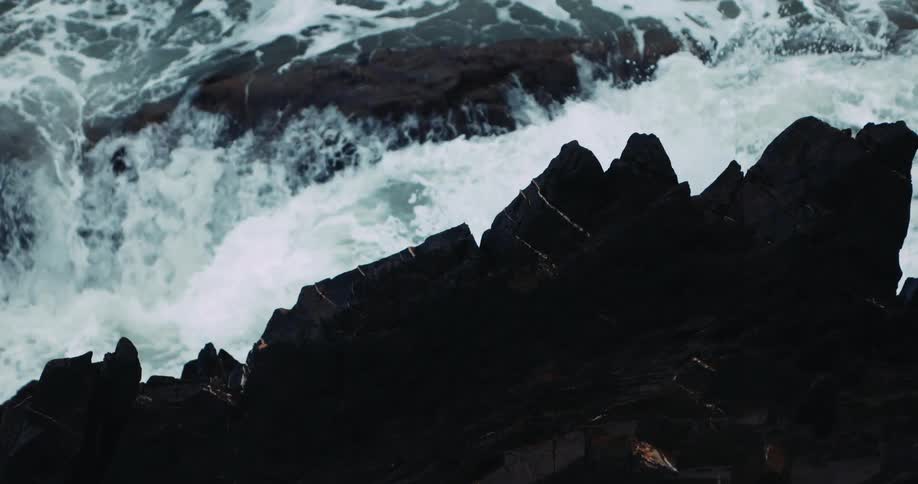 Foamy ocean waves crash against oceanside cliff