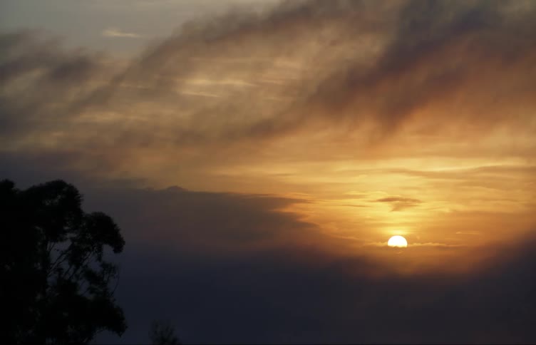 The sun is rising behind the thick clouds