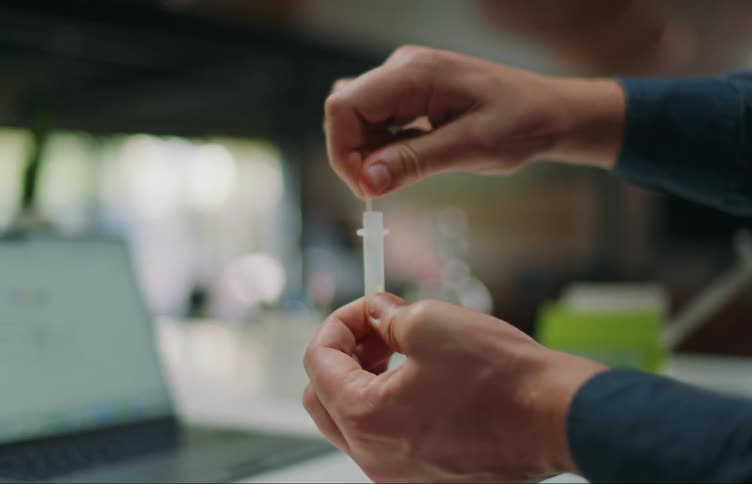 Man works with sample at table near laptop