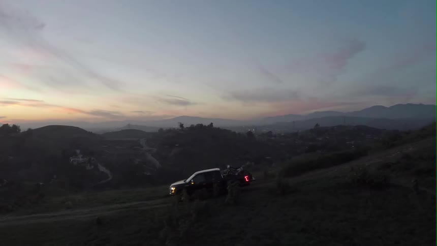 A truck descends a hill at dusk