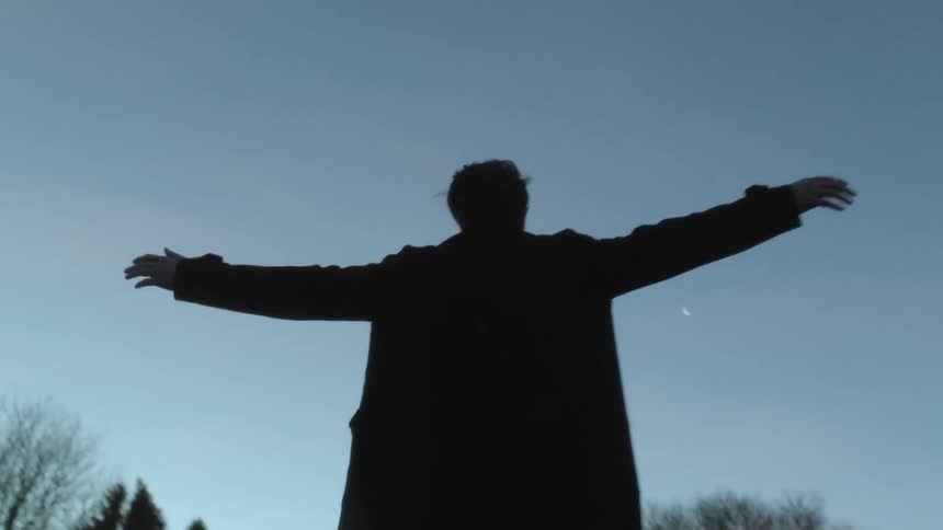 A man raises his arms towards the sky