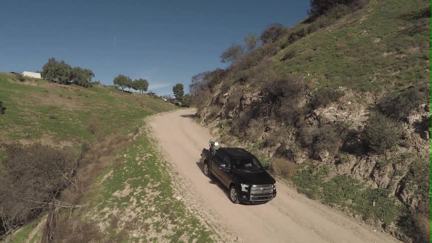 A truck driving down a dirt road