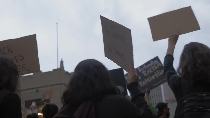 A group of people protests against racisim by carrying black lives matter signs