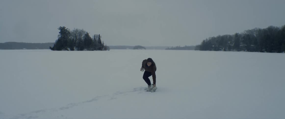 A female is outdoors in winter with ice skates