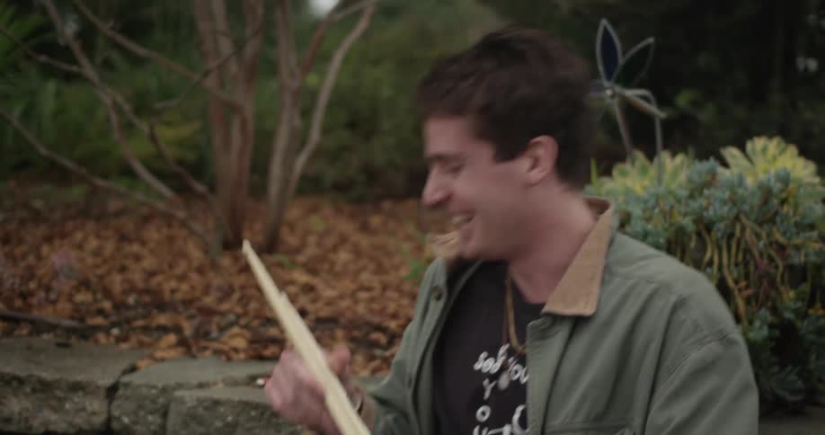 A man laughs and pulls out drum sticks