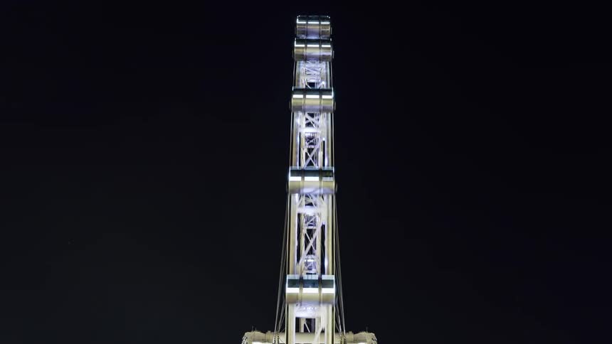 The ferris wheel is spinning at night