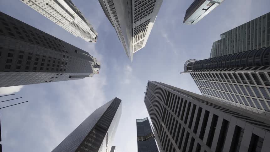 Dense clouds float past tall skyscrapers