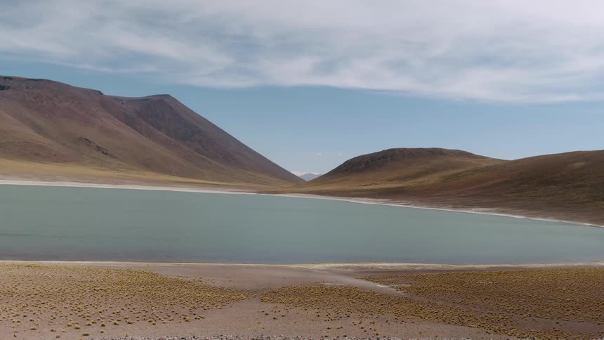 Aerial view of a calm lake on a valley between low mountains at daytime