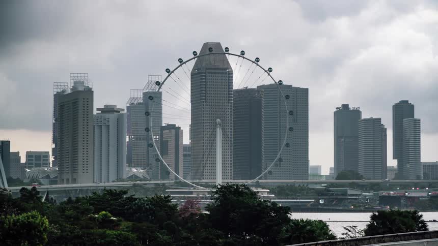 Time lapse of the singapore flyer ferris wheel spinning in front of the city skyline