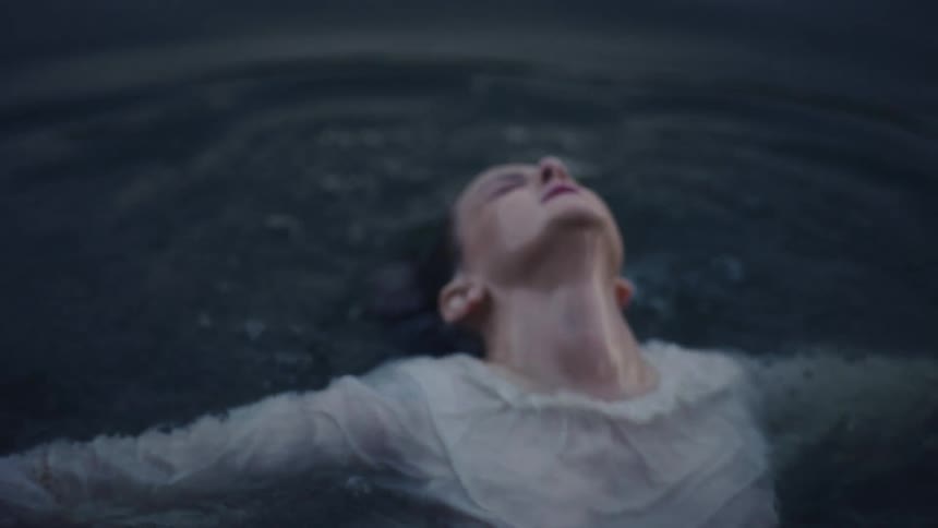 Woman with white shirt emerges from water