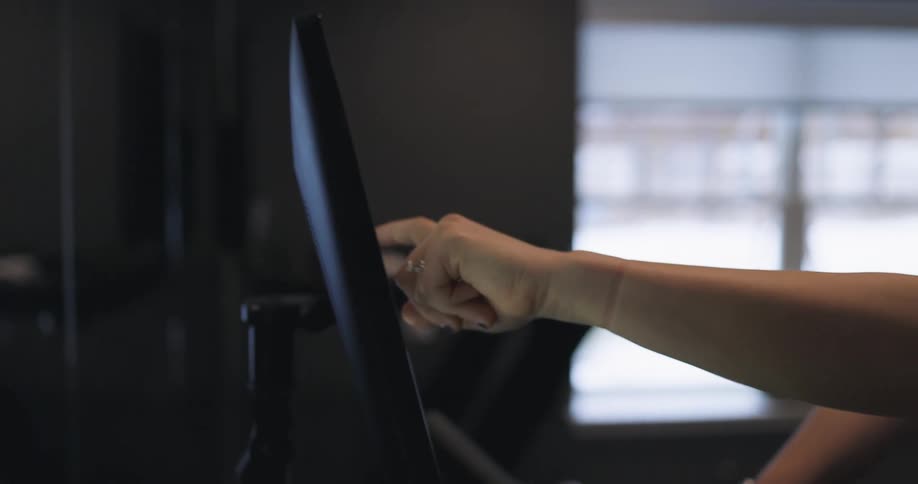 Woman programs exercise machine using touch screen