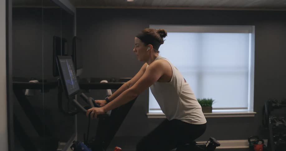 A woman is exercising on the stationary bike
