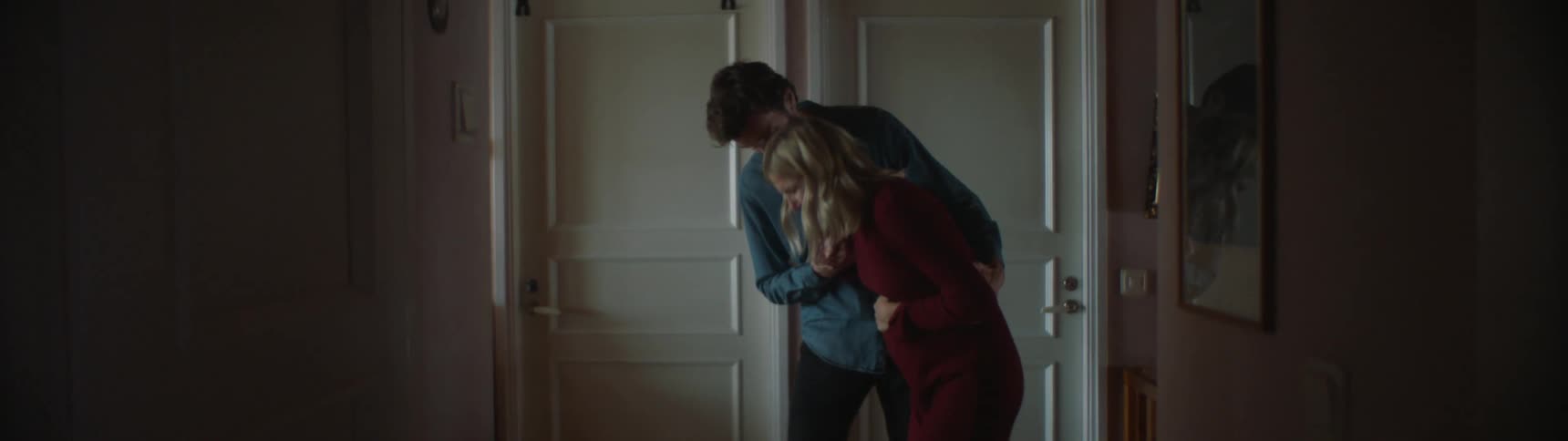 Man helps a woman in labor walk down the hallway