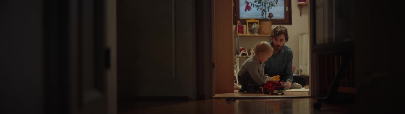 Father talks to son as boy plays with toy fire engine