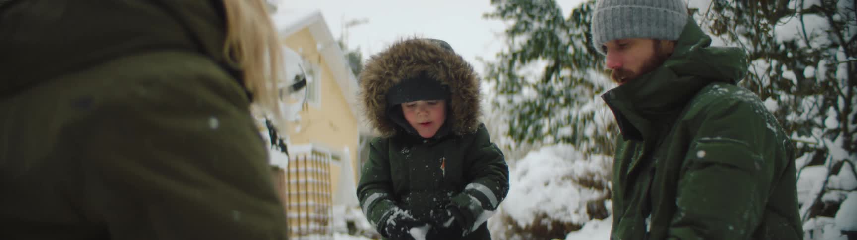 A family has a snowball fight outside