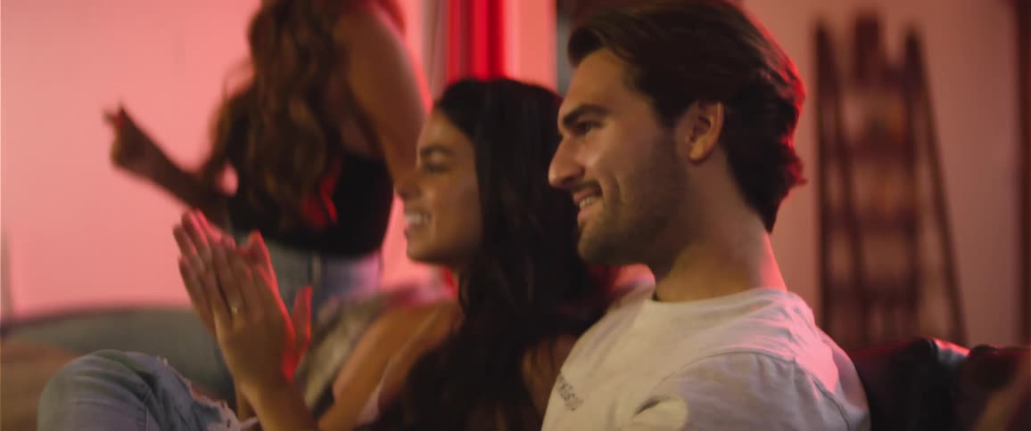 A group of people sit indoors and clap