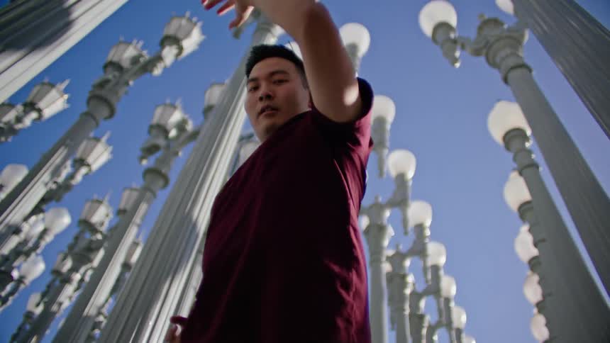 A man dances in between lamp posts close together