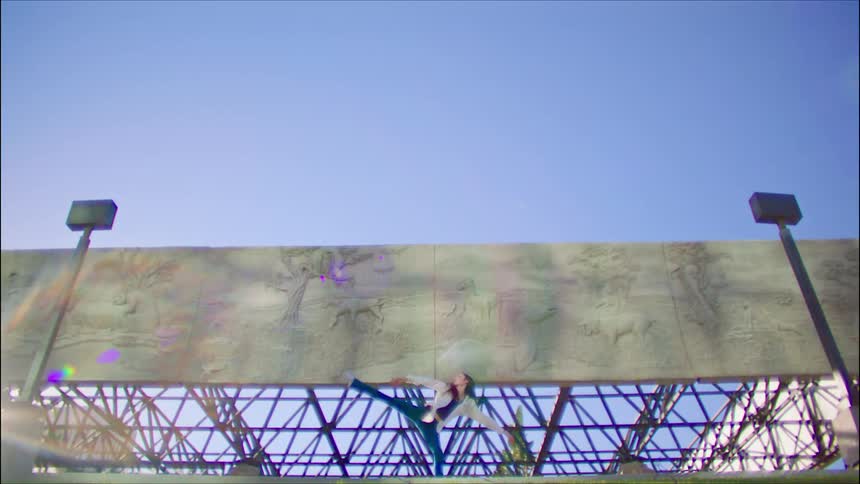 A woman is dancing under the billboard