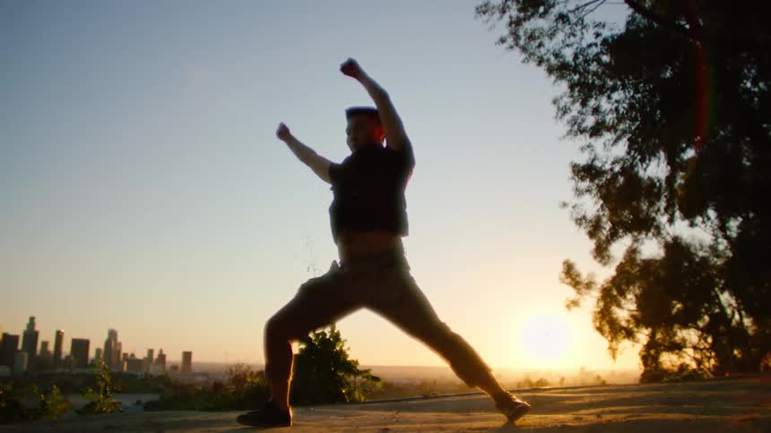 A man stretches in a park across from downtown