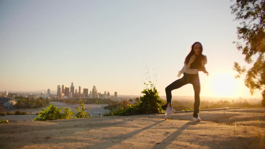 A woman is dancing on the hill