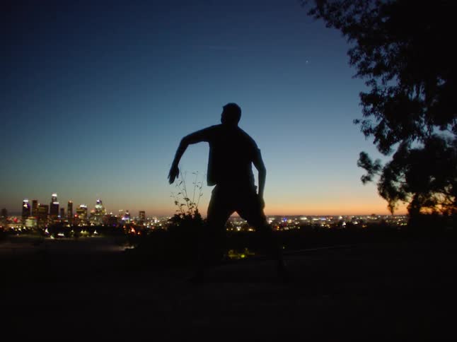 A man is dancing at sunset