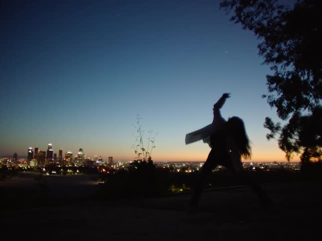A woman is dancing in the dark