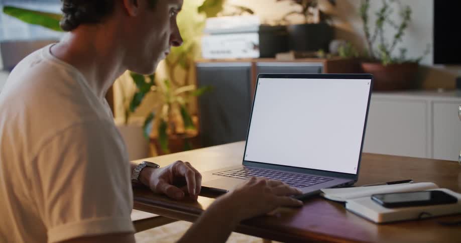 A man sits at a laptop with motion tracking markers on the screen