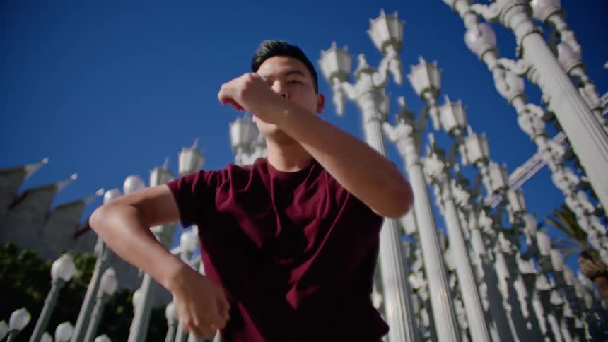 A man dancing in front of the urban lights landmark in los angeles