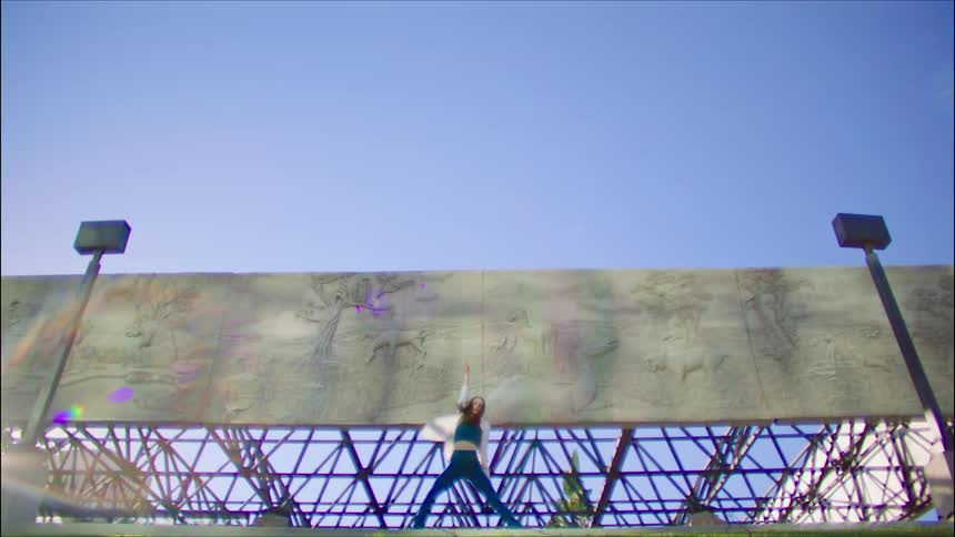 A woman is dancing under the billboard