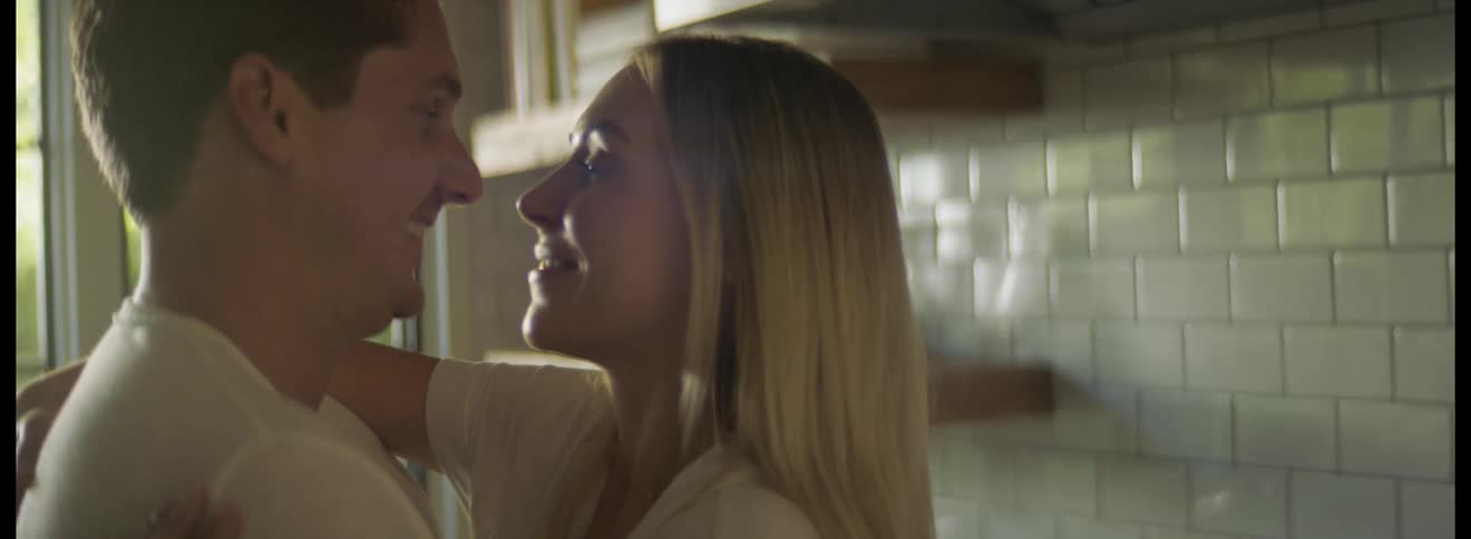 Happy excited couple kissing and hugging in their kitchen