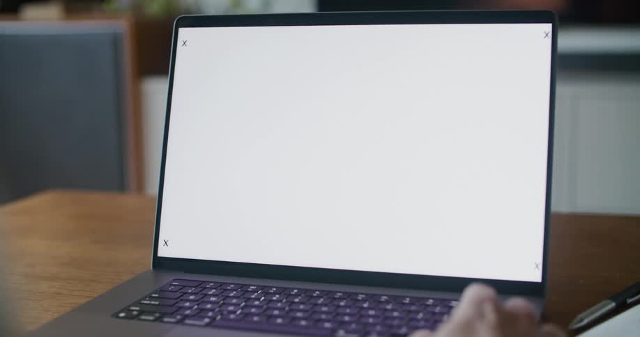 A man sits at a laptop with motion tracking markers on the screen