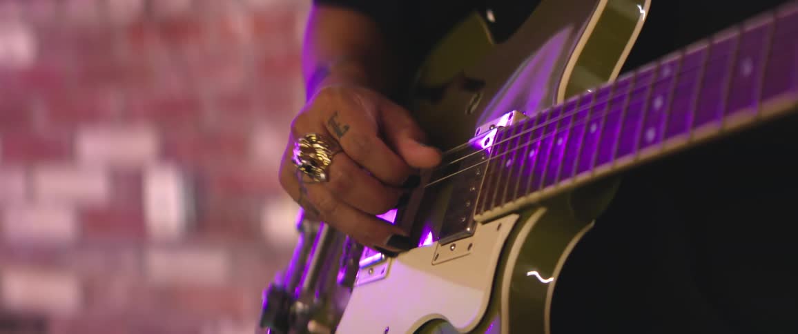 A man is strumming the guitar