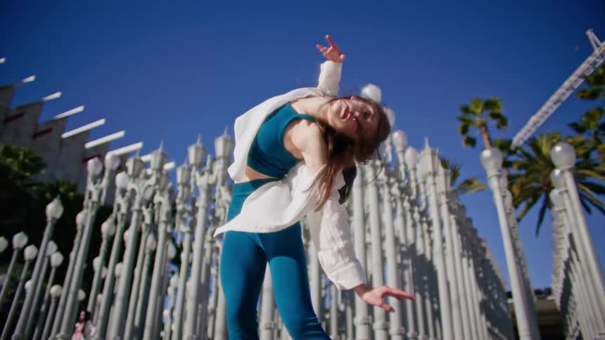 A woman is dancing by the lamp posts