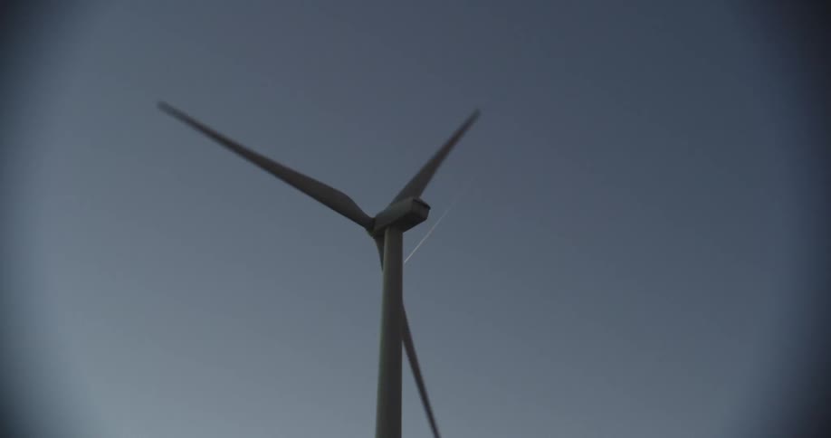 A wind turbine is spinning in a clear sky