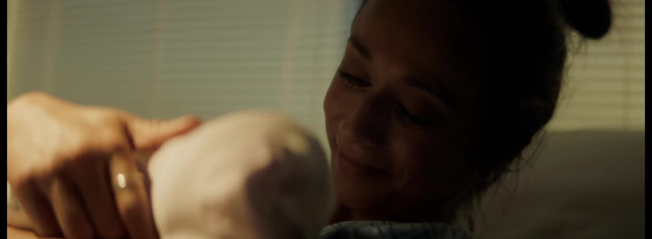 Happy new mother holding newborn after childbirth in hospital