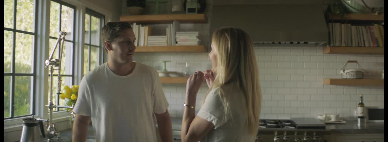 Woman surprises her partner with a pregnancy test in the kitchen at home in the morning