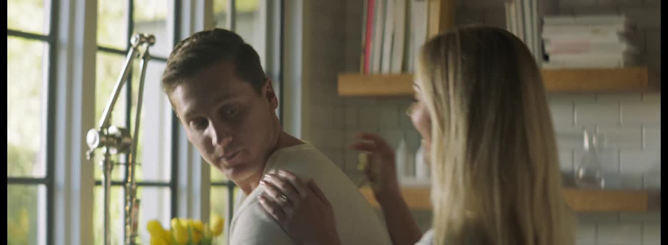 Man serving coffee in the kitchen at home is surprised by his wife at morning