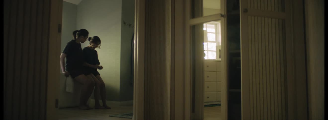 Woman sits down next to a sad woman on the bathroom at home