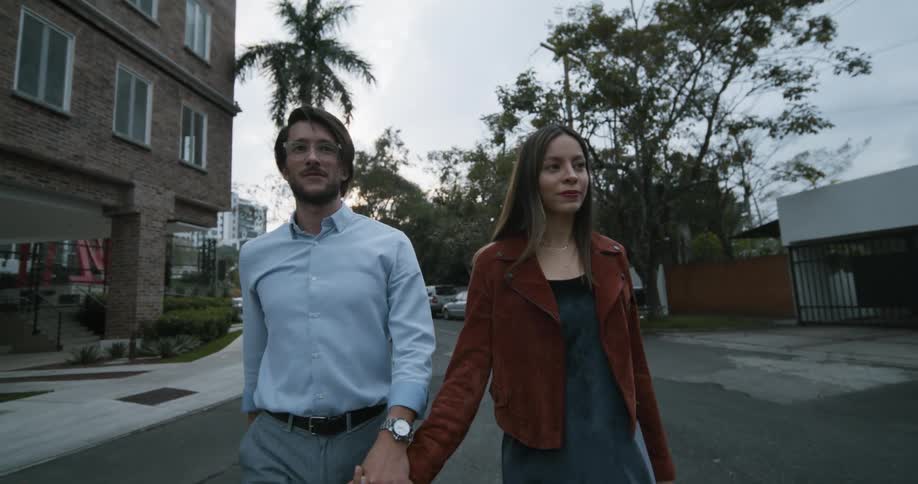 A couple hold hands while walking down the street