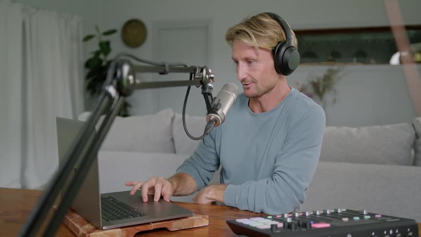 Man records from home using laptop and soundboard