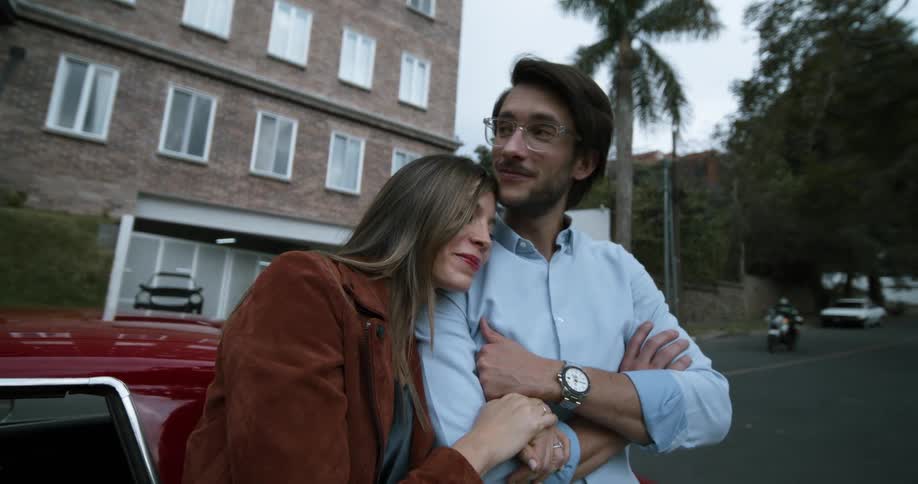 A couple hug by the car
