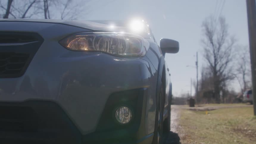 Car parking on the curb of a road in a neighborhood turns on emergency lights