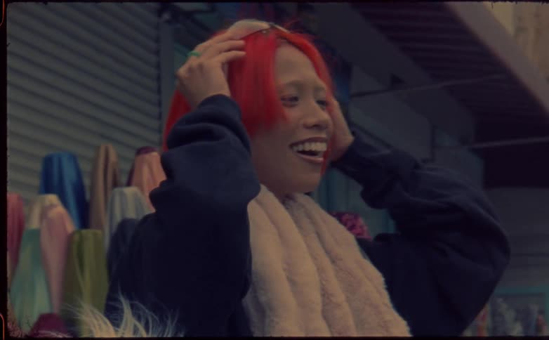 Young woman with red hair standing on a street shop in the city caught on vintage film