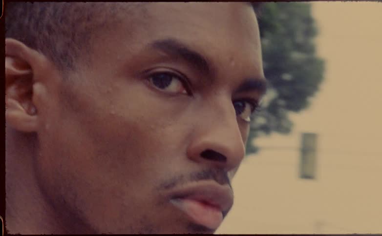 A man looks to his right while standing downtown