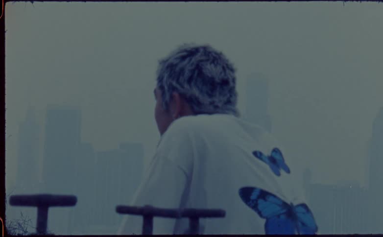A man stands and looks towards the city skyline