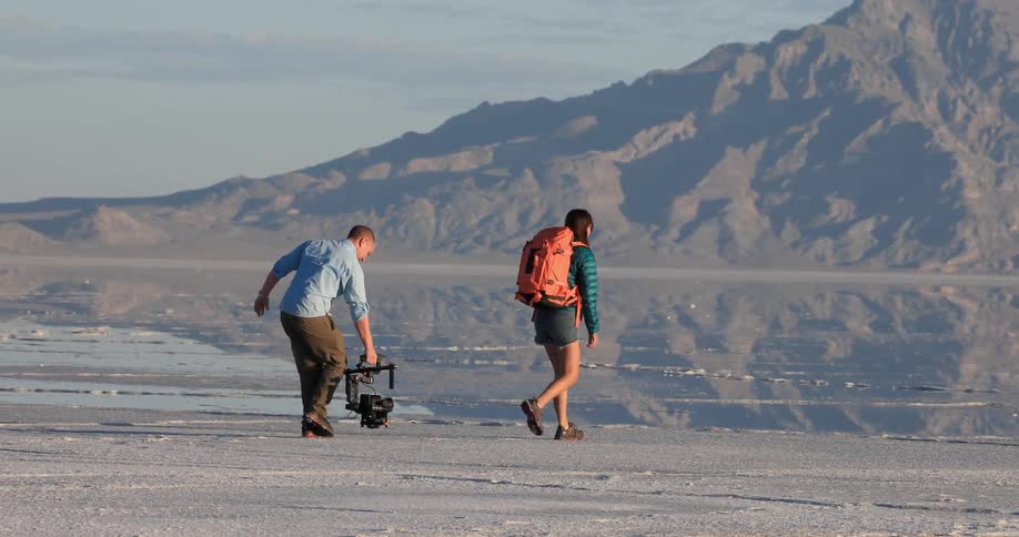 A man is filming a hiker with a hanging camera