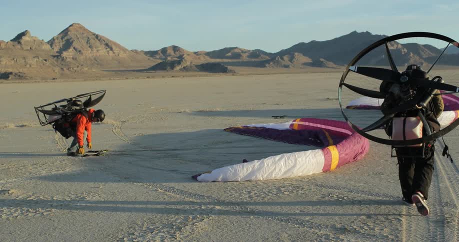 Men gathering their gliders while paramotoring
