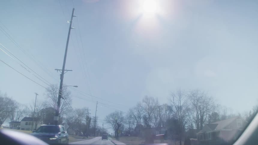 Vehicles pass each other while driving through a small town