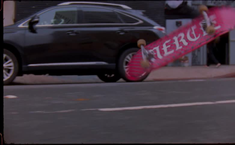 Man with brown pants white socks and black shoes skateboards on asphalt road in the street