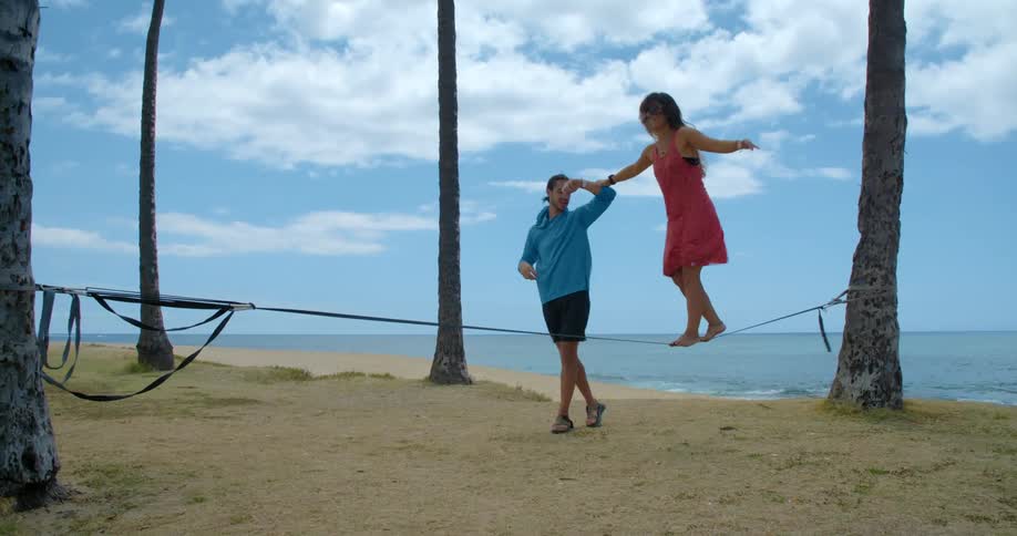 A man and woman doing slack line